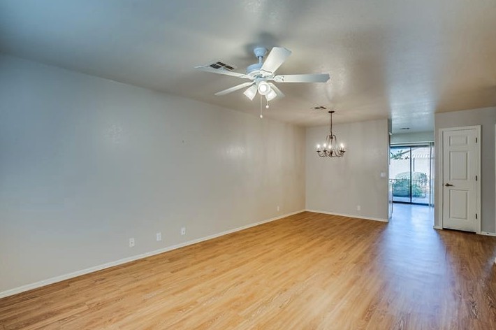 A modern living room with wood flooring and a ceiling fan.