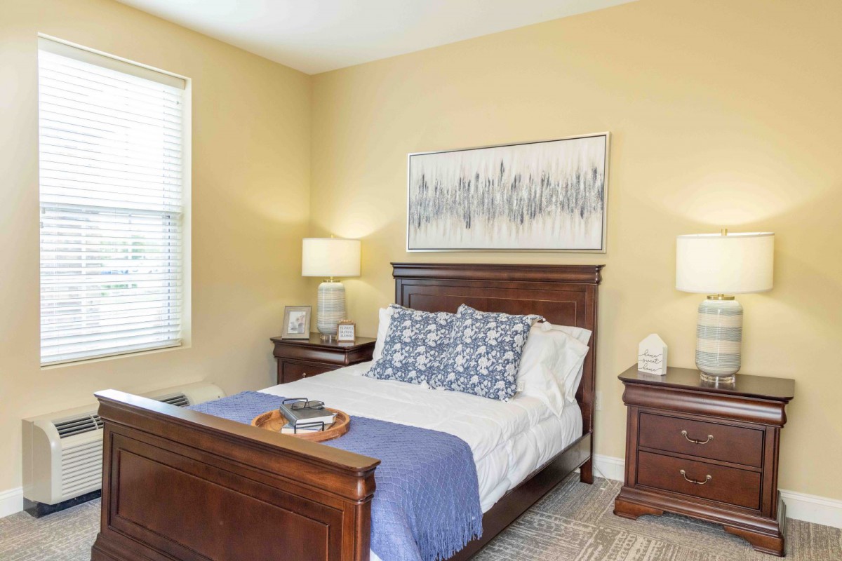 A cozy bedroom with a wooden bed frame, nightstands, and stylish decor.