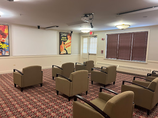 A meeting room setup with comfortable seating, a projector, and decorative wall art.