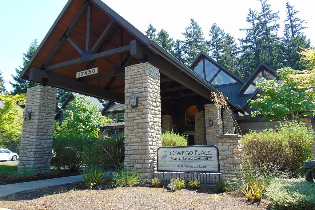 Main entrance of a building surrounded by trees with a visible sign.