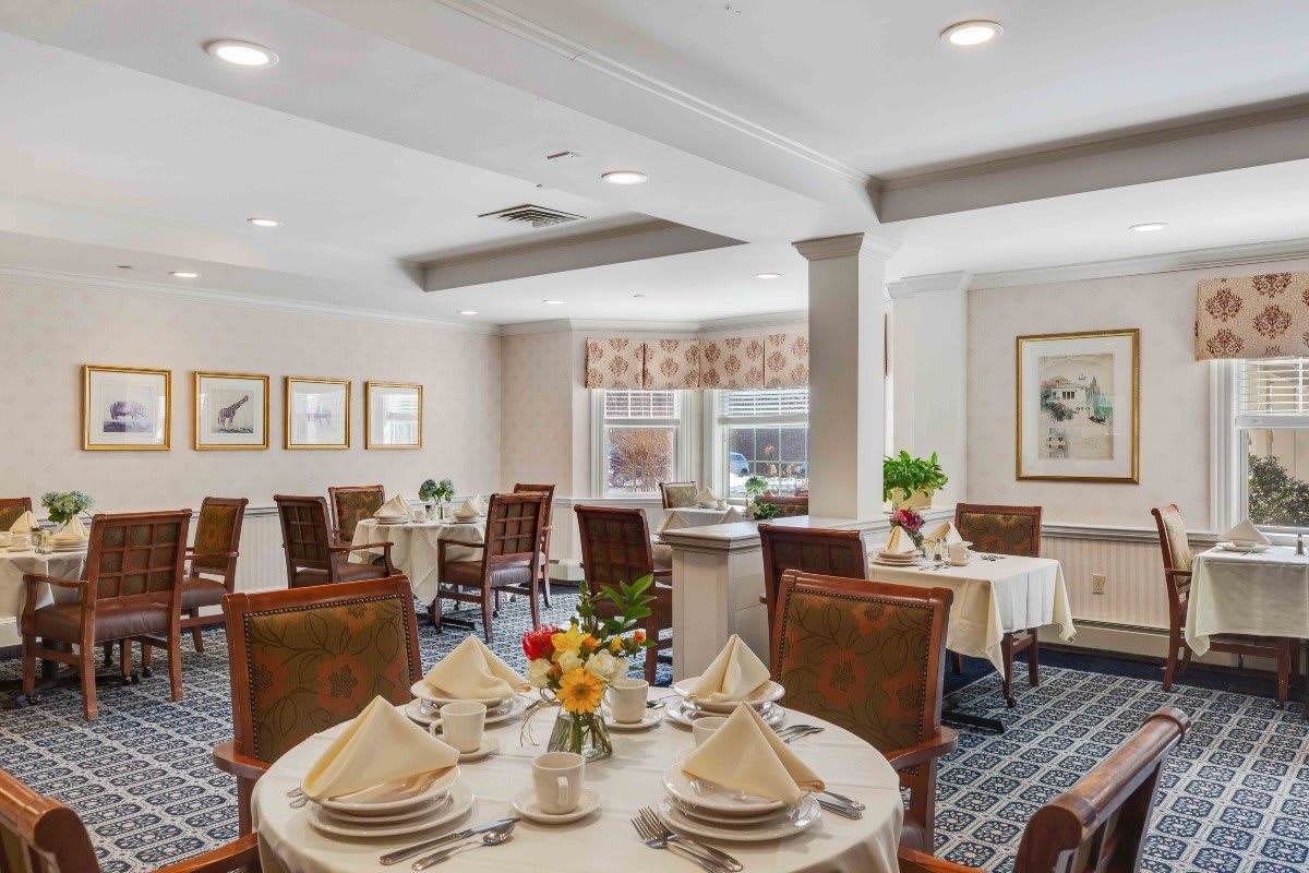 A elegantly set dining room with formal table settings and warm decor.