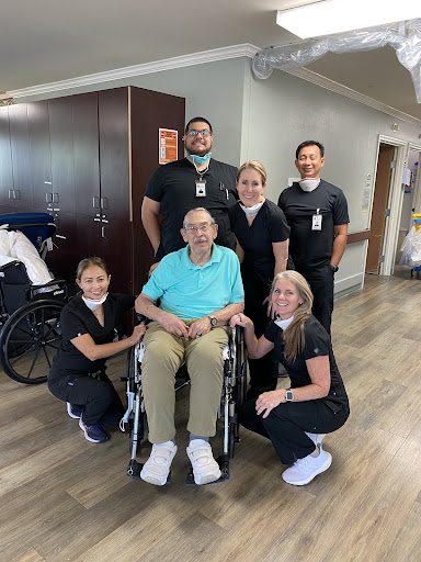 Healthcare team with a patient in a cheerful moment.