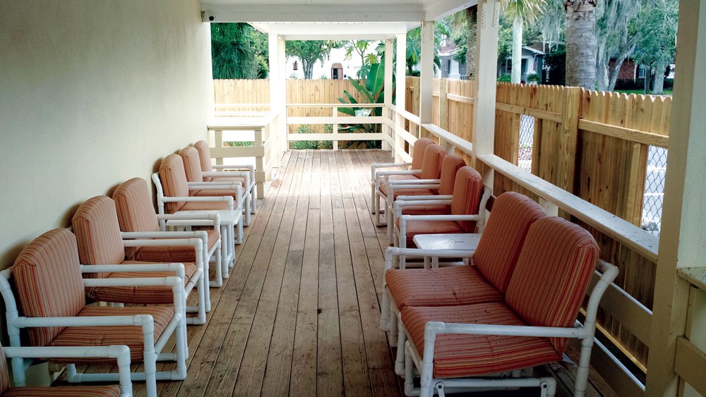 A wooden deck with cushioned chairs arranged neatly along both sides.