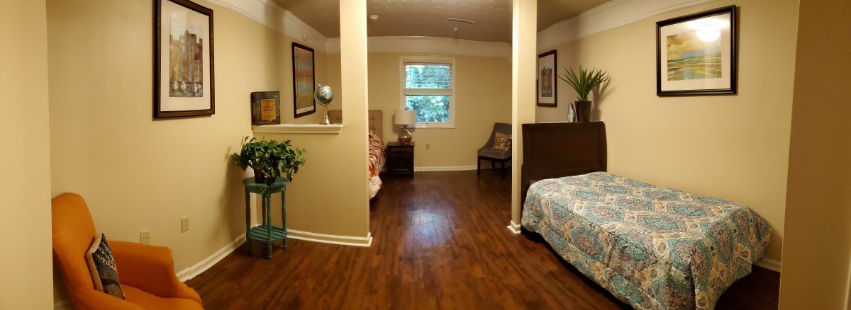 A cozy bedroom with twin beds and a wooden floor.