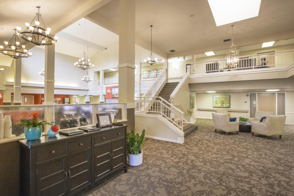 A spacious lobby area with elegant furnishings and a central staircase.