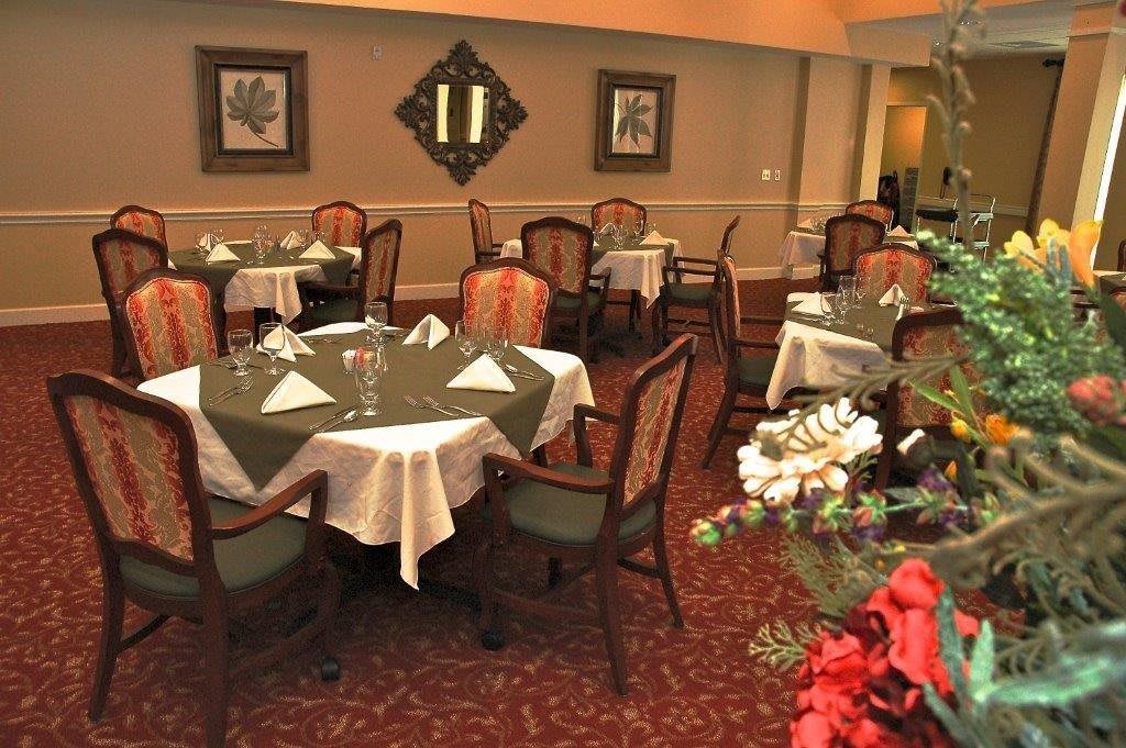 Elegantly set dining area with tables and chairs.