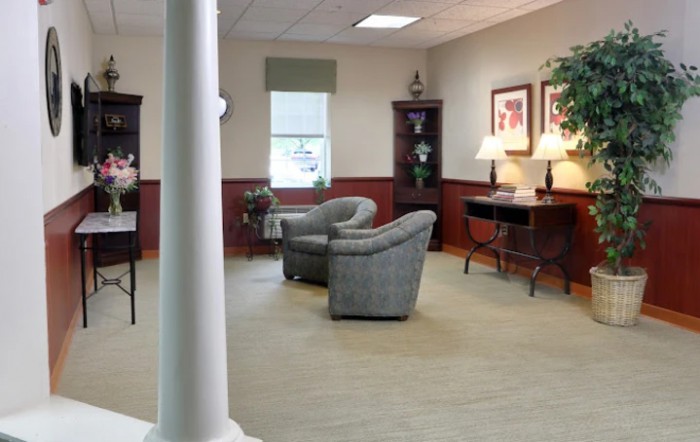 A cozy living room with comfortable seating, bookshelves, and ambient lighting.