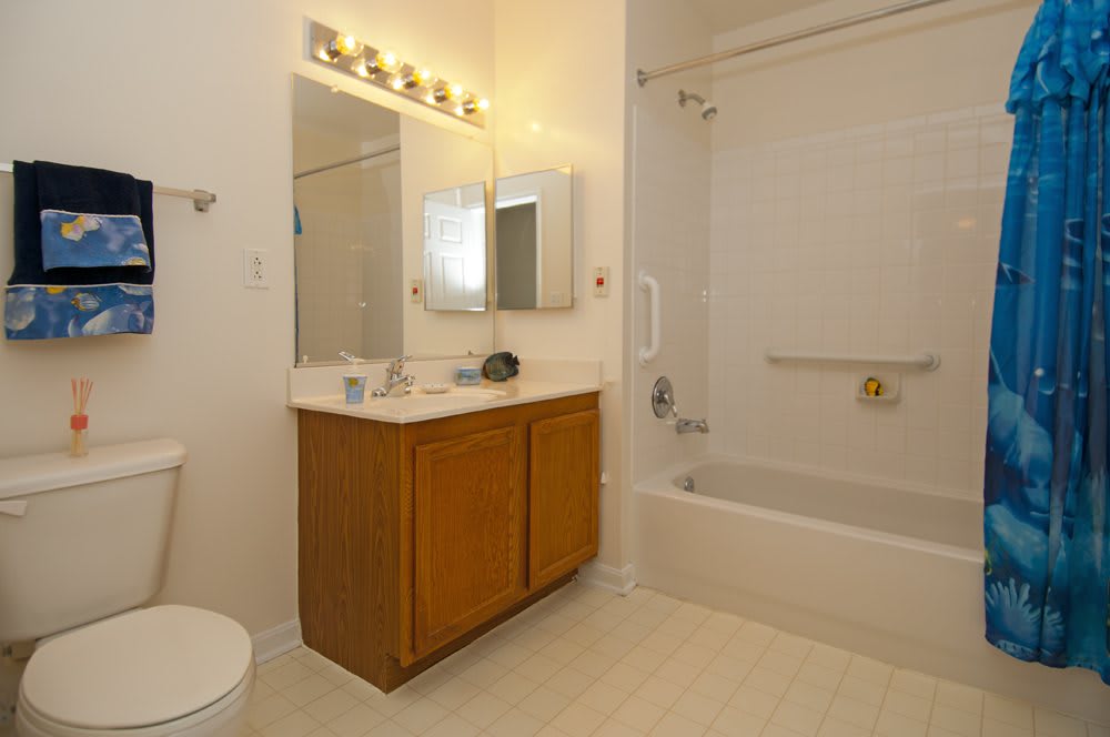 A clean and minimalistic bathroom with a vanity, mirror, lighting, and bathtub.