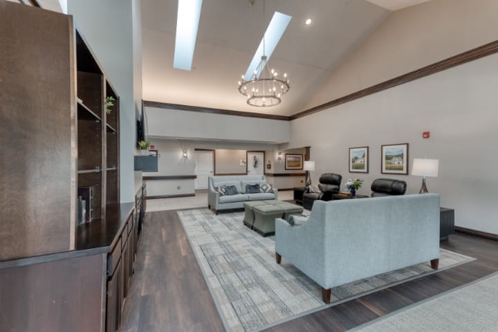 A modern living room with high ceilings, featuring elegant furniture and a striking chandelier.