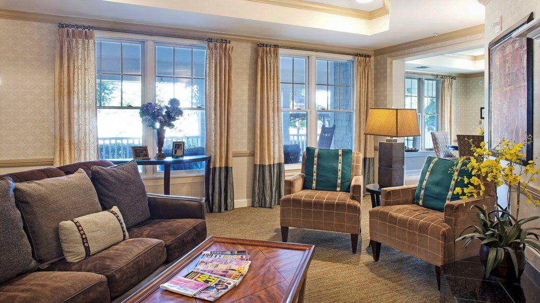 A cozy and elegant living room with comfortable seating and natural light streaming through large windows.
