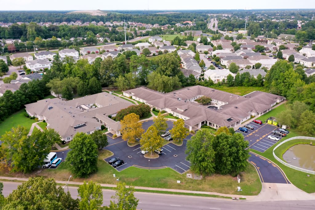 Aerial view of a suburban residential area with houses, roads, and greenery.