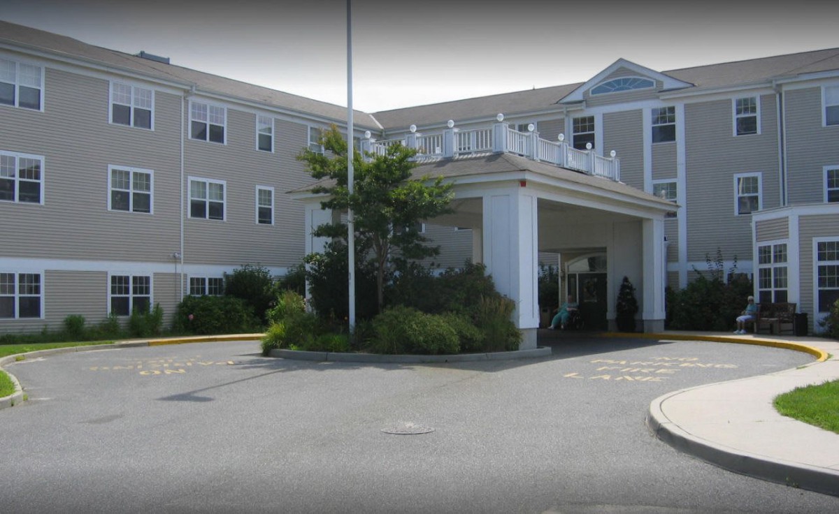 A hotel entrance with landscaping and a covered driveway.