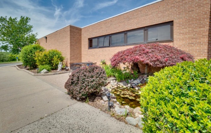 A brick building with well-maintained landscaping and a small garden.