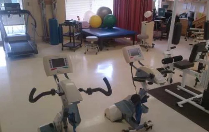 A rehabilitation room equipped with stationary bikes and therapy balls.