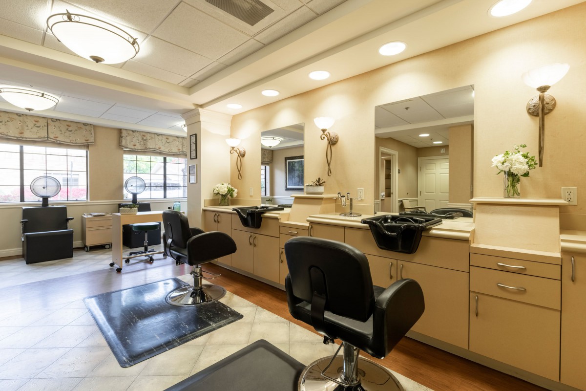 An interior view of a modern hair salon with barber chairs and mirrors.