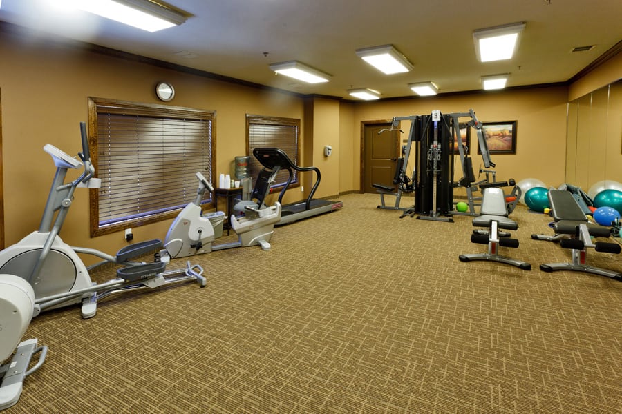 Image of a gym with various fitness equipment and exercise machines.