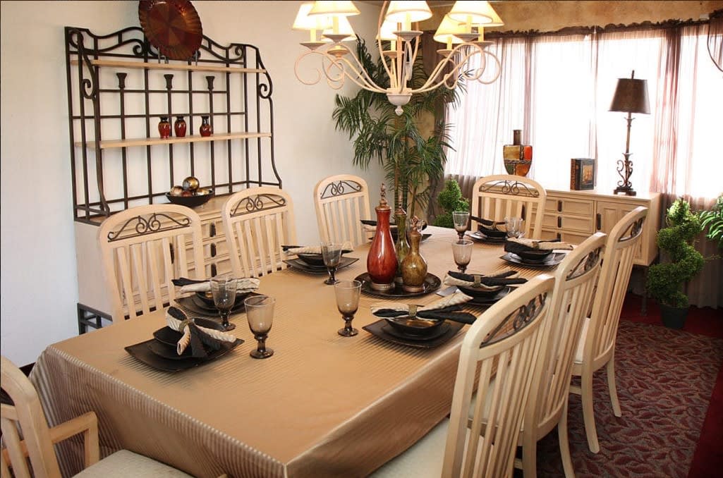 A well-decorated dining room with an elegant table setting and chandelier.