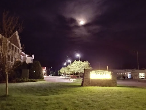A serene night scene featuring a glowing sign under a partially obscured moon.