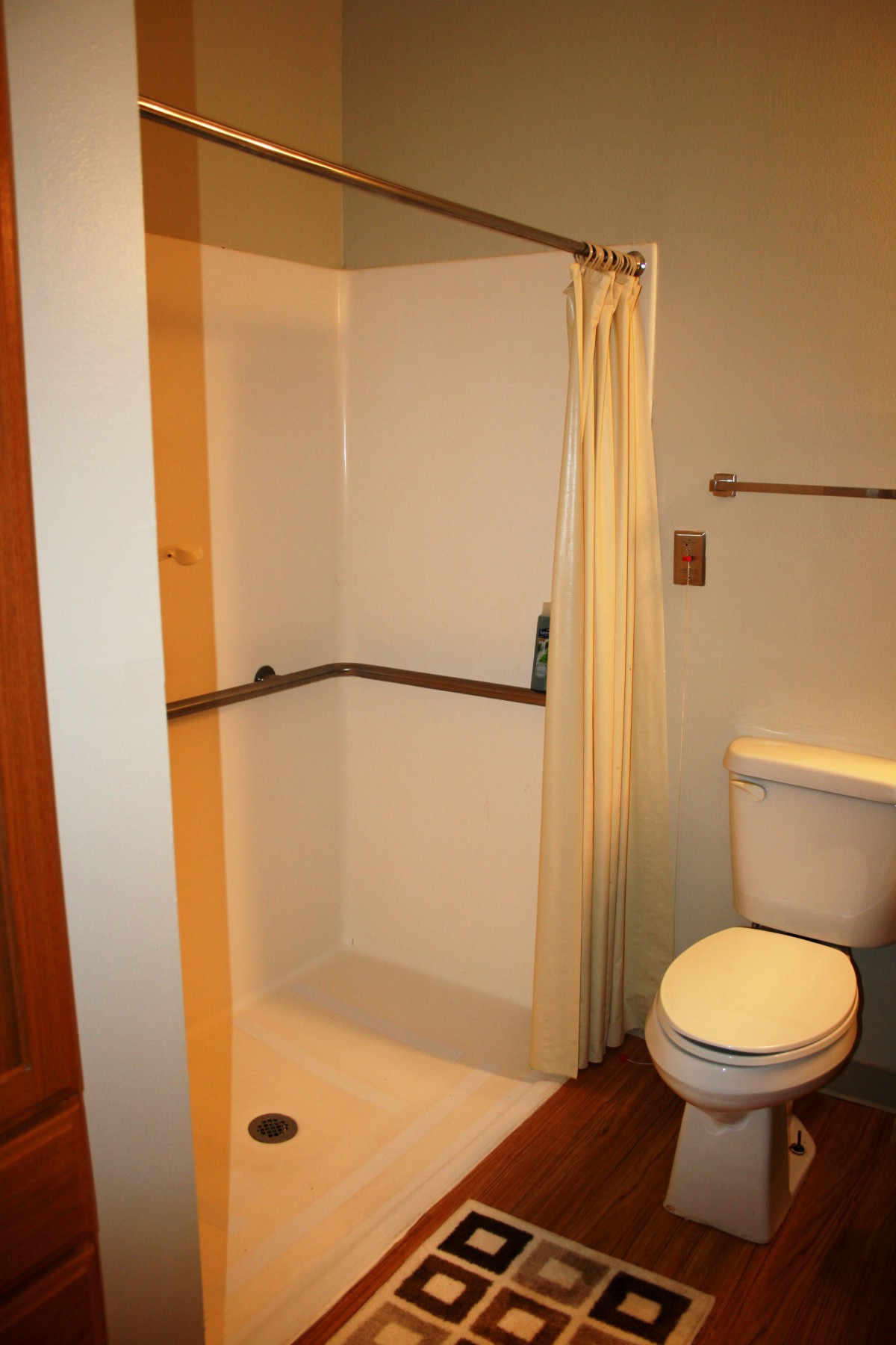 A bathroom featuring a shower with a curtain and a toilet.