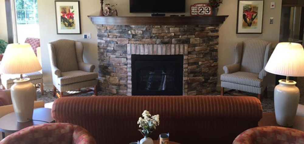 Cozy living room with a stone fireplace and TV above the mantel.