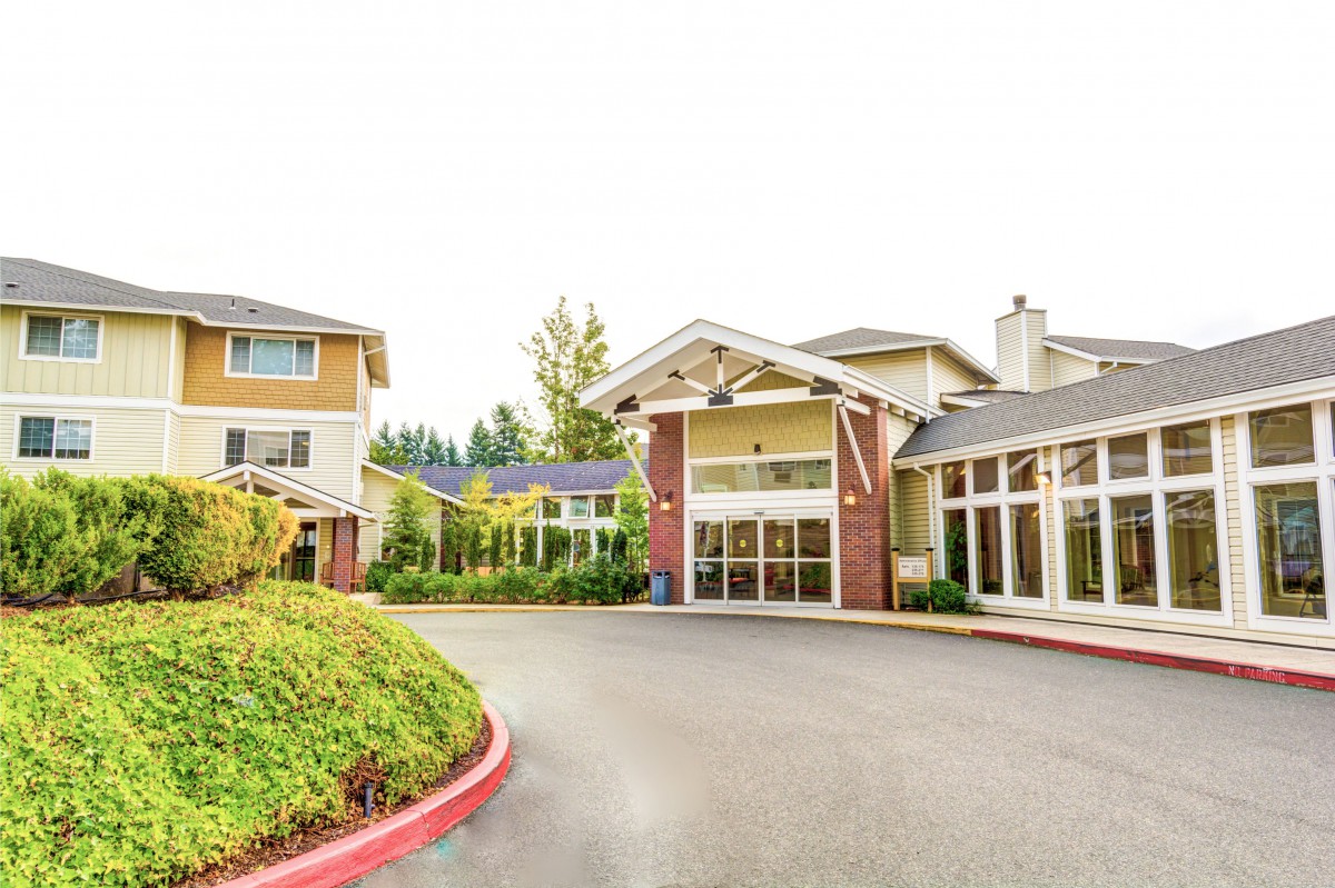 A spacious and welcoming residential building with a landscaped driveway entrance.