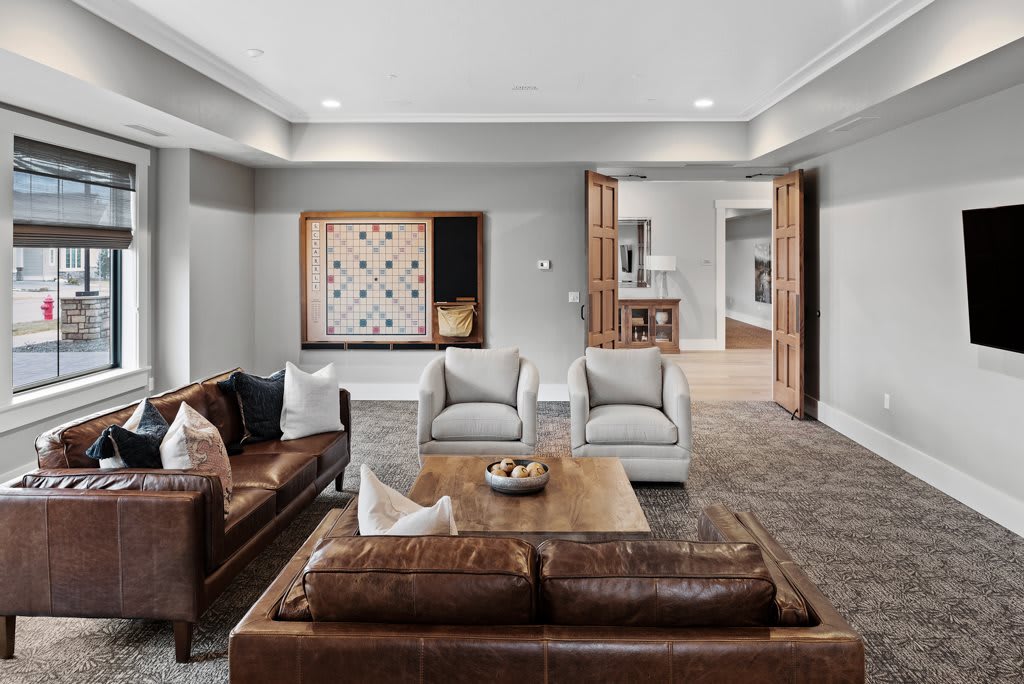 A modern living room with leather sofas, armchairs, and a wooden coffee table.