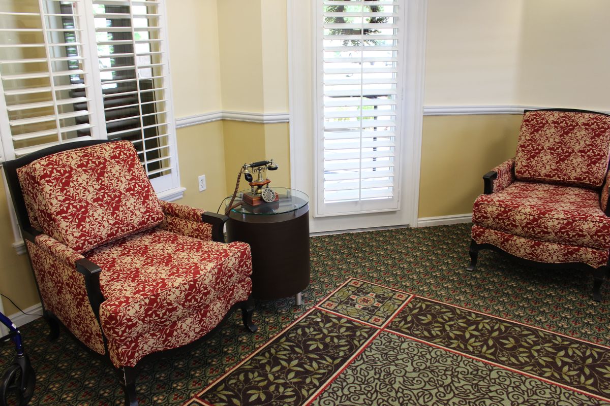 A cozy living room with patterned chairs and a decorative carpet.
