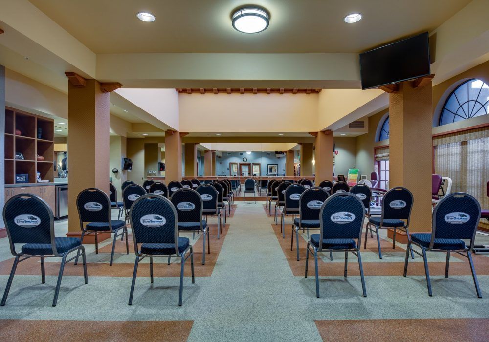 An empty conference room with rows of chairs arranged in a symmetrical pattern.