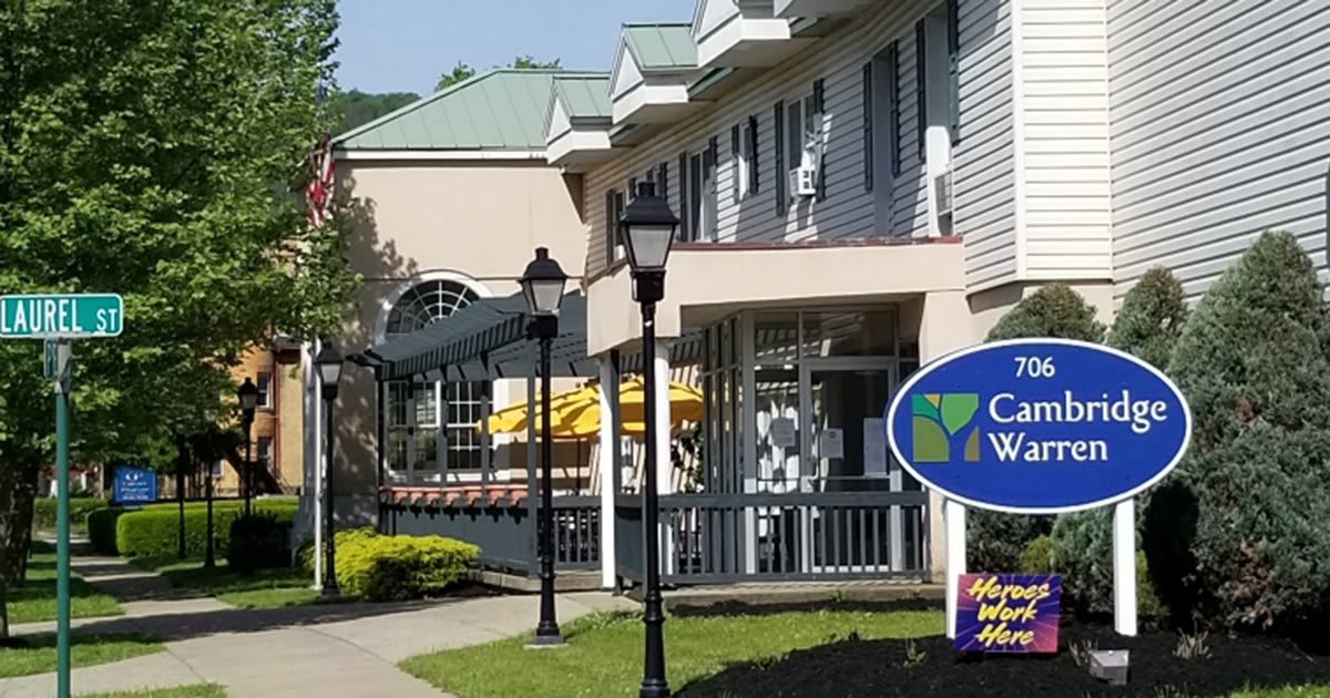 A view of a commercial building with a sign and outdoor seating.