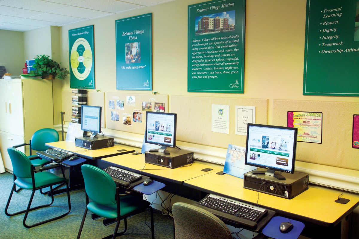 A computer lab with multiple workstations and educational posters on the walls.