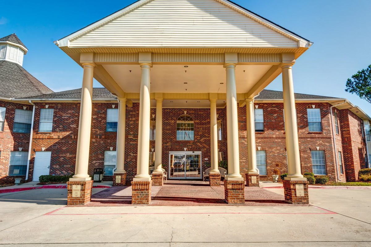 Front entrance of a hotel with large columns and brick facade.