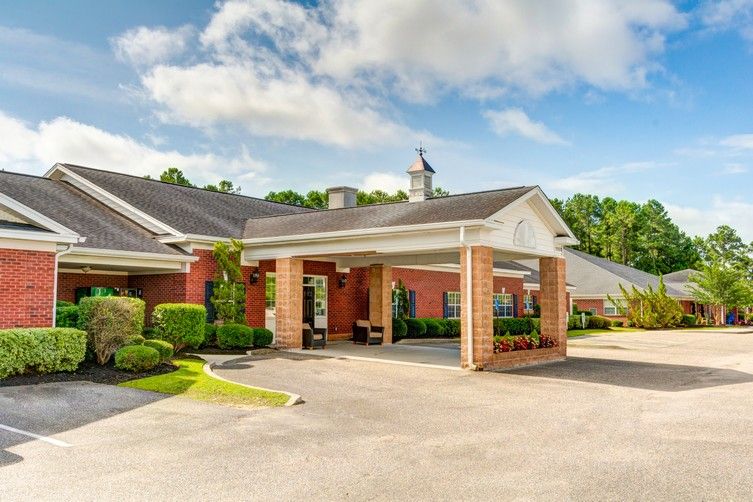 A well-maintained building entrance with a driveway and landscaping.