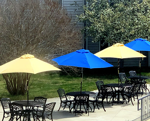 A vibrant outdoor seating area featuring yellow and blue umbrellas next to tables.