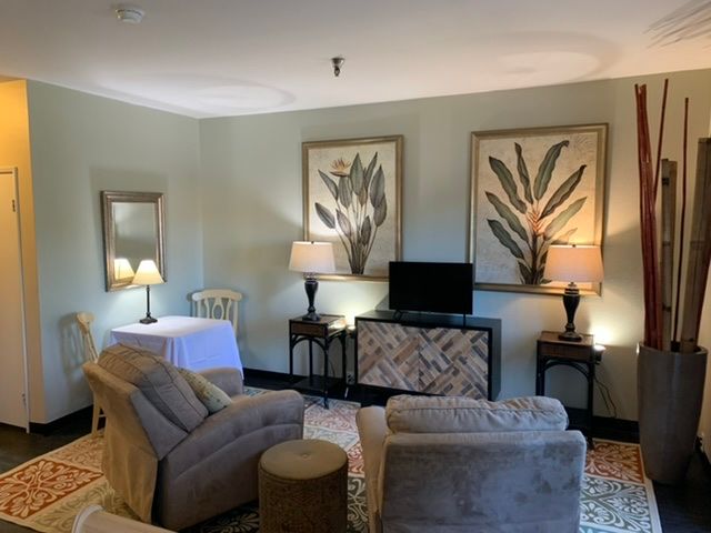 A cozy living room with comfortable seating, decorative artwork, and ambient lighting.