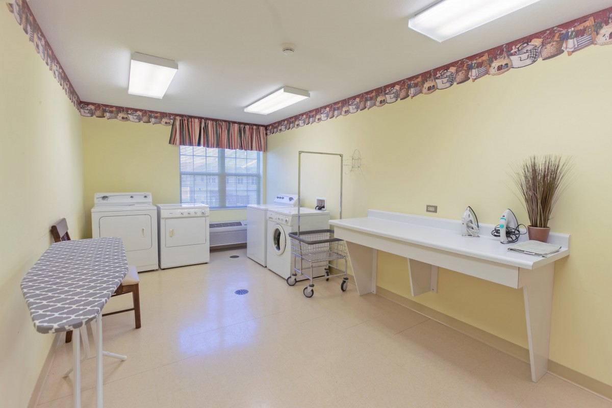 A clean and organized laundry room with washing machines and a folding area.