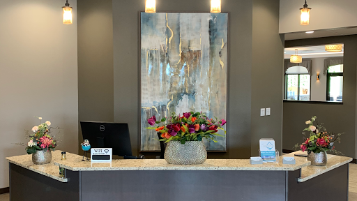 A modern reception area featuring a beautiful floral arrangement and contemporary artwork.