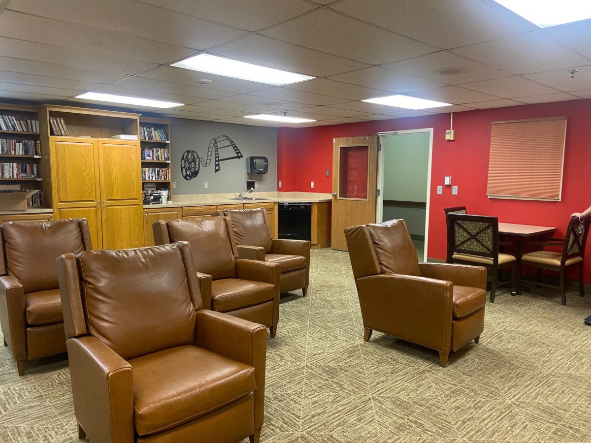 A cozy lounge area with brown recliner chairs and a carpeted floor.