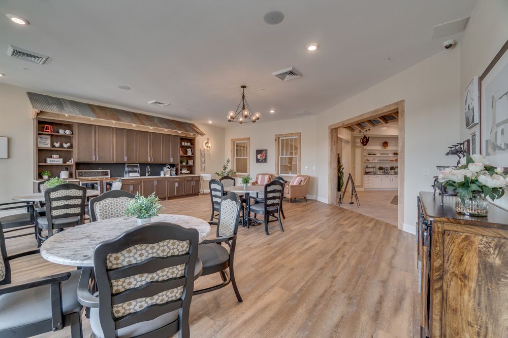 A spacious, modern open-plan kitchen and dining area with wood flooring and stylish lighting fixtures.