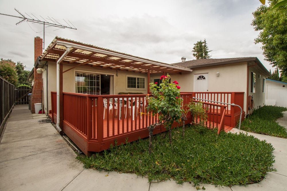 A house with a wooden deck and garden area.