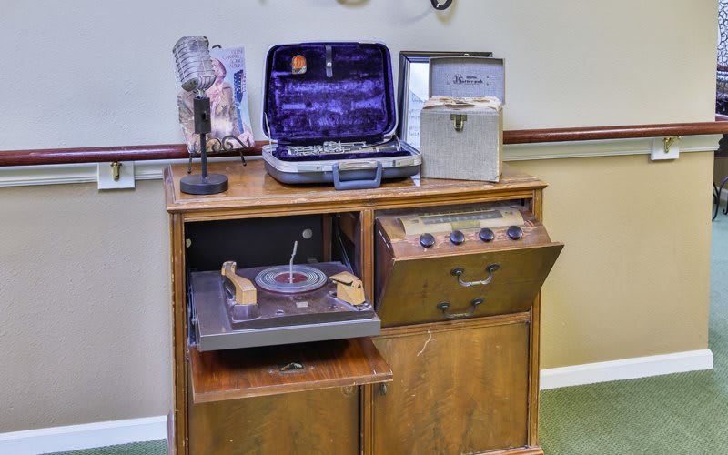A vintage audio setup featuring a record player, microphone, and various retro audio equipment housed in a wooden cabinet.