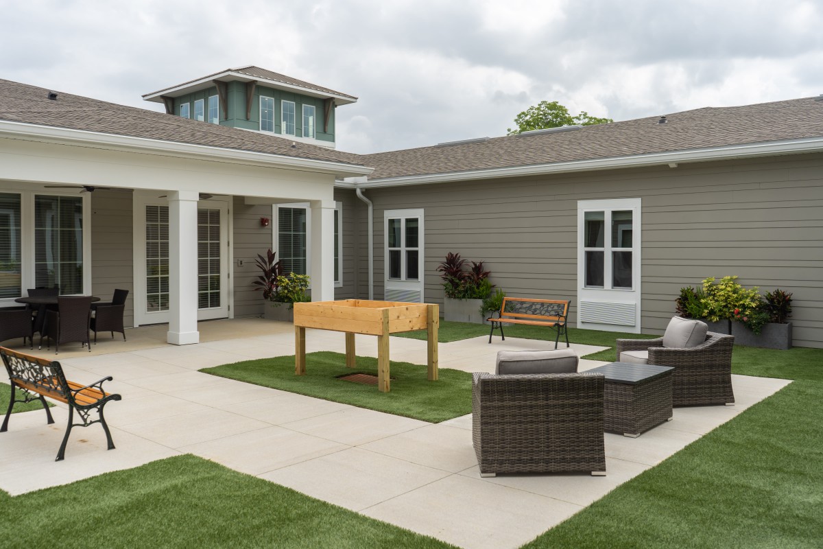 A modern outdoor patio area featuring comfortable seating and a well-maintained lawn.