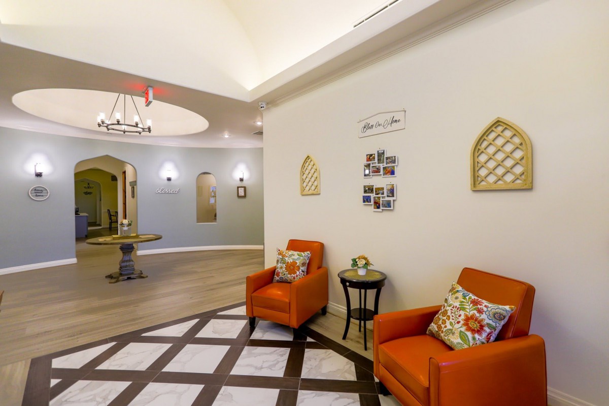 A cozy waiting area with orange chairs and decorative wall art.