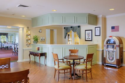 A cozy reception area with a round table, chairs, and decorative elements.