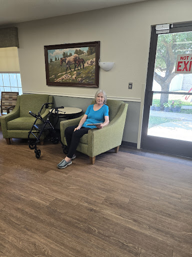 An elderly woman enjoying a moment of relaxation in a community seating area.