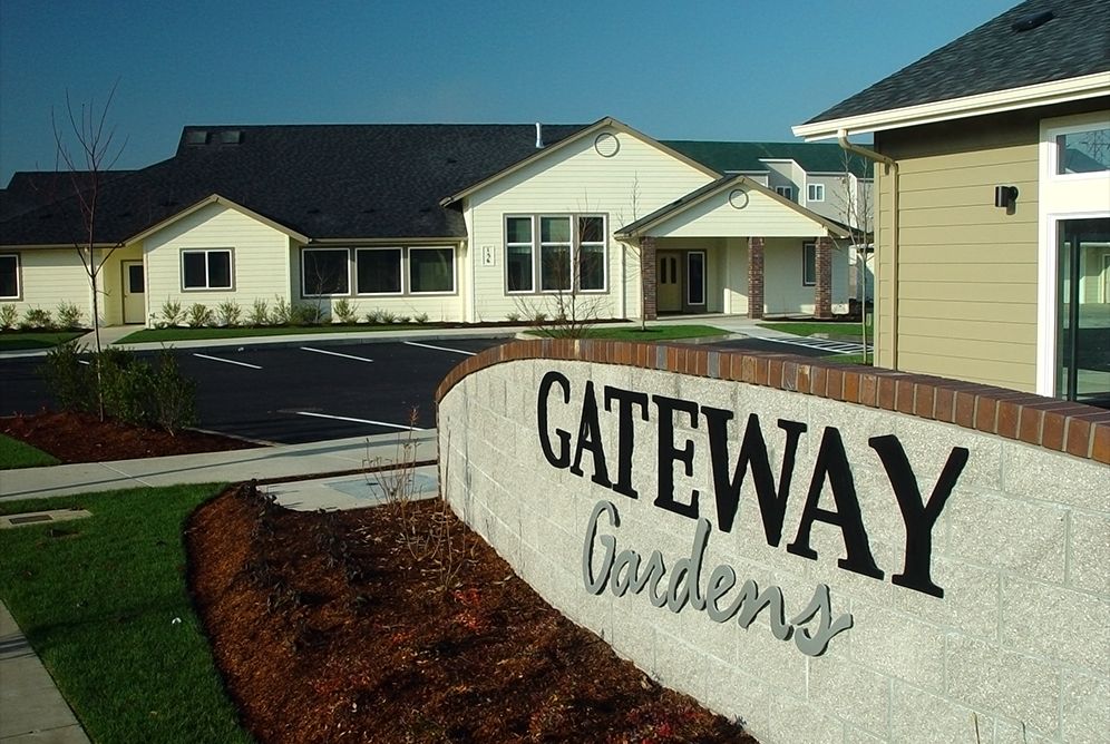A view of the Gateway Gardens residential complex sign and buildings.