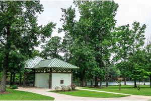 A peaceful park setting with a pavilion surrounded by lush trees and greenery.