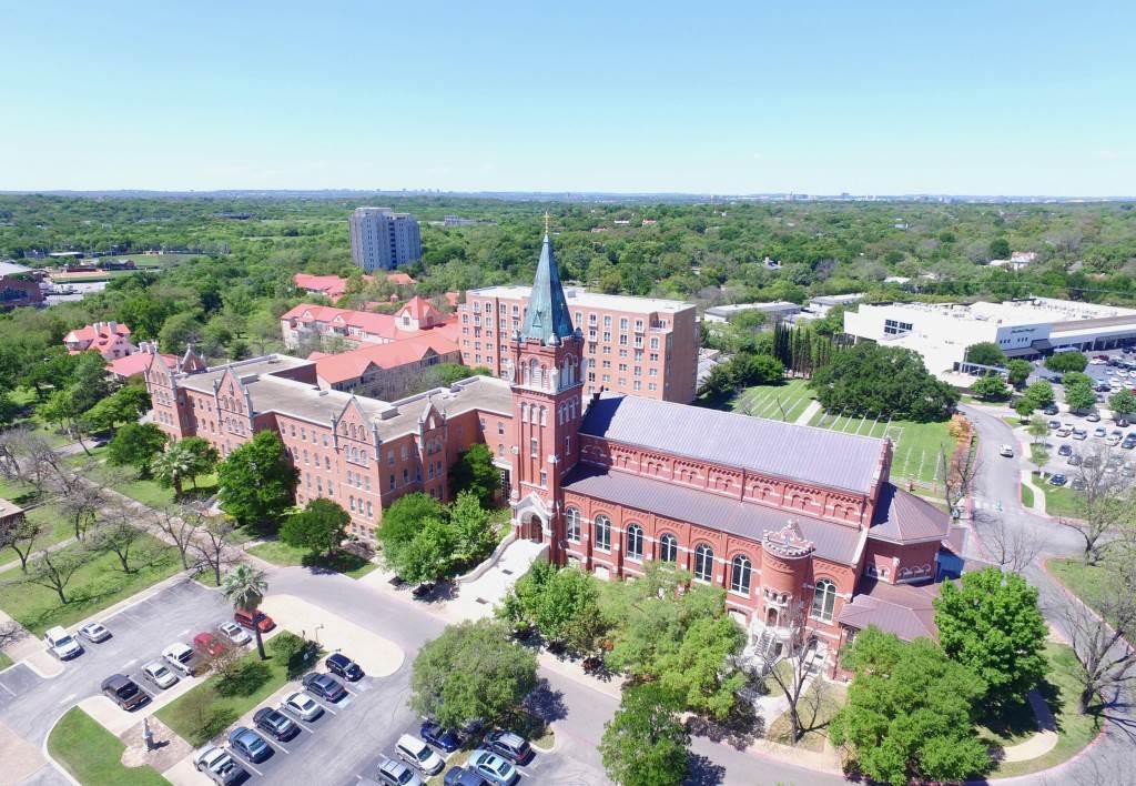 Aerial view of a university campus with historic buildings and surrounding greenery.