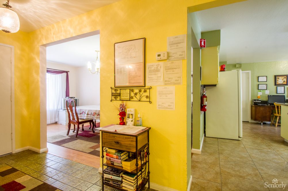 A cozy interior showcasing a yellow wall with a view into the dining and kitchen areas.