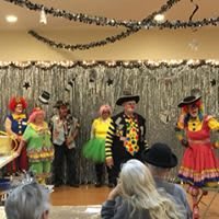 A group of clowns performing on stage in front of an audience.