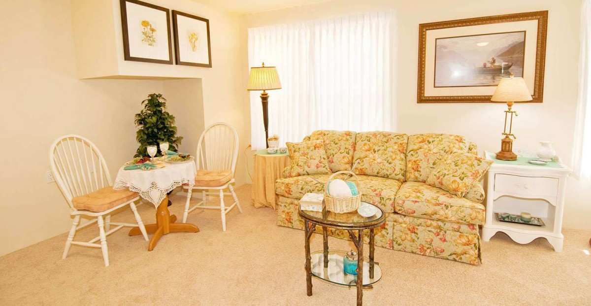 A cozy living room with a floral sofa and decorative elements.